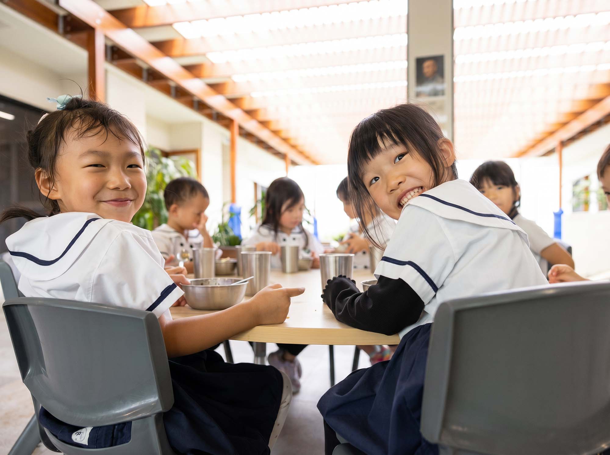 Tzu Chi children sitting, giggling, eating fresh vegetarian meals